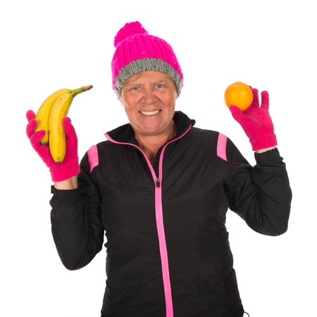 Old Fit sporty Healthy winter woman with fruit isolated over white backgroundの写真素材