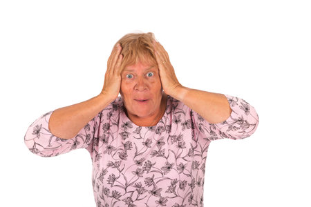 Portrait surprised blonde senior woman on white backgroundの写真素材