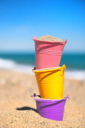 Colorful toy buckets at the beachの写真素材