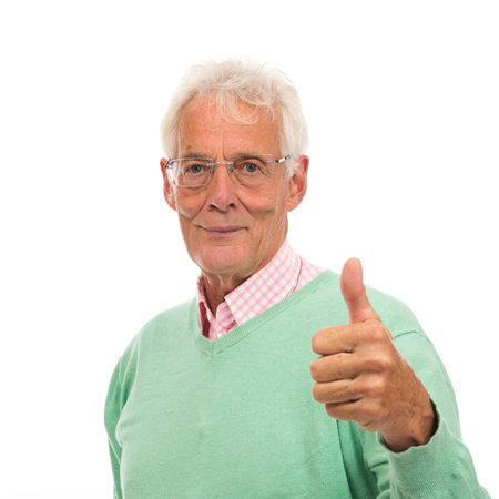 Senior man in green sweater thumbs up isolated over white backgroundの写真素材