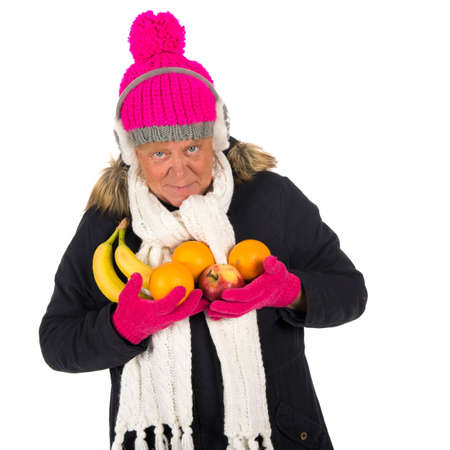 Healthy winter woman with fruit isolated over whiteの写真素材