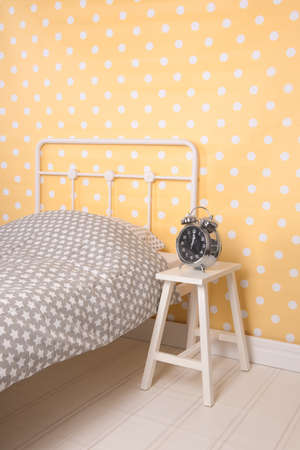 Yellow Bedroom with single bed and alarm clockの写真素材
