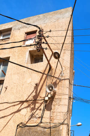 Typical electricity and electricity wires on old house in Spainの写真素材