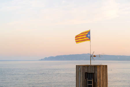 Landscape with flag in front of Les Medes islands in sunset at the horizonの写真素材