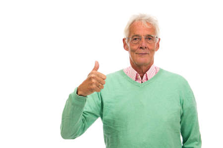 Senior man in green sweater thumbs up isolated over white backgroundの写真素材