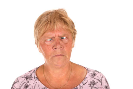 Portrait blonde senior woman with squint eyes isolated over white backgroundの写真素材