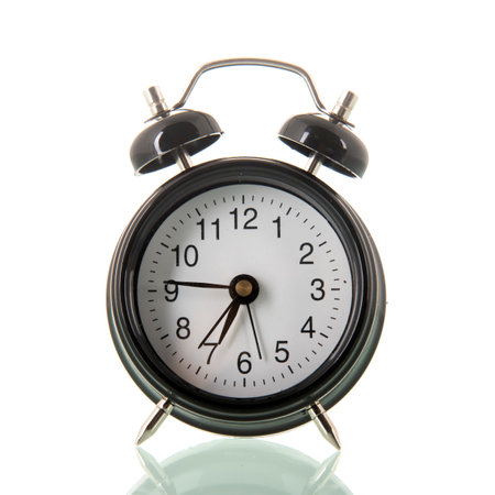 Black alarm clock at seven isolated over white backgroundの写真素材