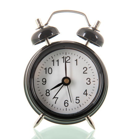 Black alarm clock at eight isolated over white backgroundの写真素材