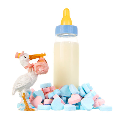 Baby bottle milk with stork and candy hearts isolated over white backgroundの写真素材