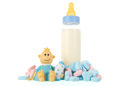 Baby bottle milk with stork and candy hearts isolated over white backgroundの写真素材