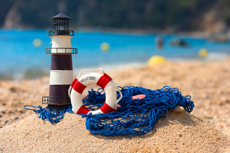 Tropical summer beach with lighthouse life buoy and fishing net