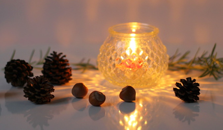 Christmas decoration with candlelight, pinecones and nuts.
