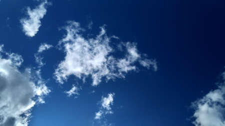 Fluffy clouds on bright blue sky. Daylight. Sky background with space for text.