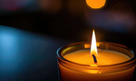 Close-up of a candle's gentle flicker illuminating a serene settingの素材