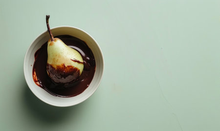 Pear and chocolate fondue on a light green surfaceの素材