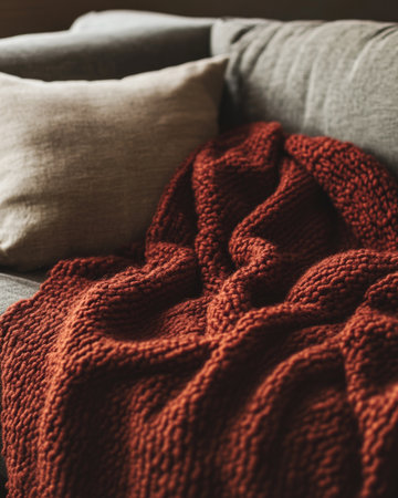 Warm, textured blanket, chunky knit, draped on a couchの素材