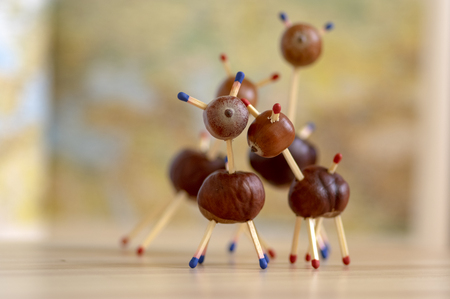 Group of funny chestnut animals on wooden table, fall background, traditional autumn handcraft, European roe deer with family made from autumn fruits and safety matchesの写真素材
