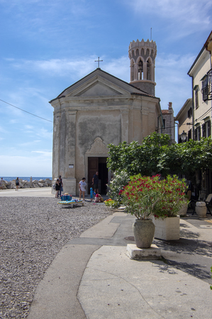 Our Lady of Health Church, Piran / SLOVENIA - June 24, 2018: Peninsula Piran coastline with church and tourists enjoying sunny dayのeditorial素材