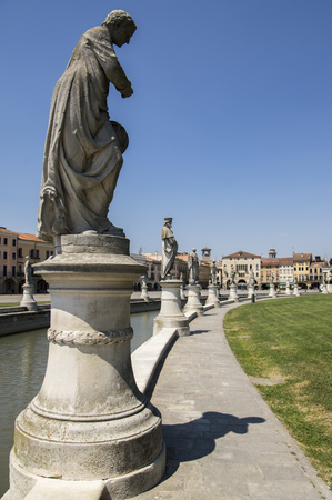 Padua / ITALY - June 12, 2017: Beautiful summer day on Prato della Valle square with water canal. Amazing white italian sculptures. Greenery, blue sky and sunlight.のeditorial素材