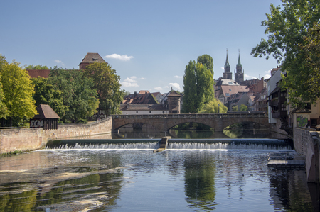 Nuremberg / GERMANY - September 17, 2018: Picturesque view of river Pegnitz in Nuremberg with water reflections. Beautiful autumnal day with blue sky, sunlight a greenery around.のeditorial素材
