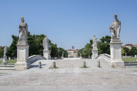 Padua / ITALY - June 12, 2017: Beautiful summer day on Prato della Valle square with water canal. Amazing white italian sculptures. Greenery, blue sky and sunlight.のeditorial素材
