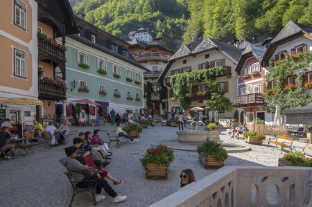 Hallstadt / Austria - September 21, 2018: Picturesque old small town with beautiful narrow streets with tourists. Autumn touristic season in sunlight with blue sky.のeditorial素材