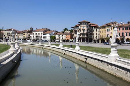 Padua / ITALY - June 12, 2017: Beautiful summer day on Prato della Valle square with water canal. Amazing white italian sculptures. Greenery, blue sky and sunlight.のeditorial素材
