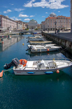 Trieste / ITALY - June 23, 2018: Canal Grande with boats on blue sea water during summer touristic...