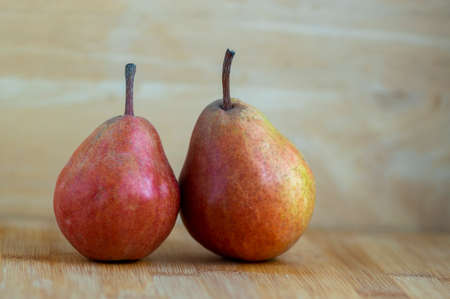 Two pears edible fruits, tasty ripened red yellow fruit still life on wooden backgroundの写真素材