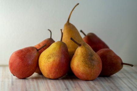 Group pears edible fruits, tasty ripened red yellow fruit still life on the tableの写真素材