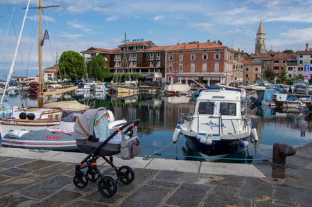 Izola, SLOVENIA - September 8, 2019: Touristic view of Izola old fishing town historic center with church tower and marina with boats in the foregroundのeditorial素材