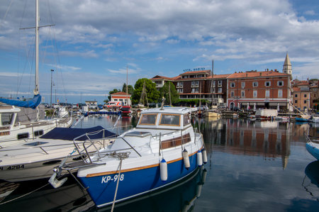 Izola, SLOVENIA - September 8, 2019: Touristic view of Izola old fishing town historic center with church tower and marina with boats in the foregroundのeditorial素材