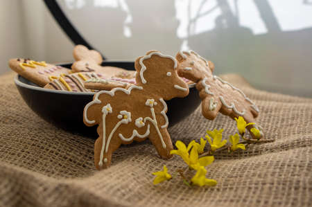 Easter holiday cookies servet on dish on the table with jute tablecloth, group of color painted...