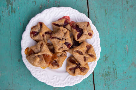 Czech cheesecake pastry folded cubes baskets biscuits wrapped filled with red jam on green blue...