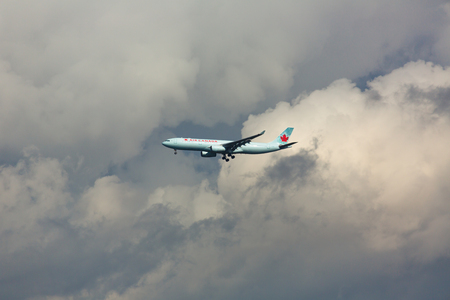 Airplane on the background of thunderstorm cloudsのeditorial素材