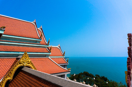 Traditional temple rooftop against blue sky and sea