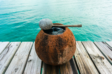 water jar on wooden floor with sea backgroundの写真素材