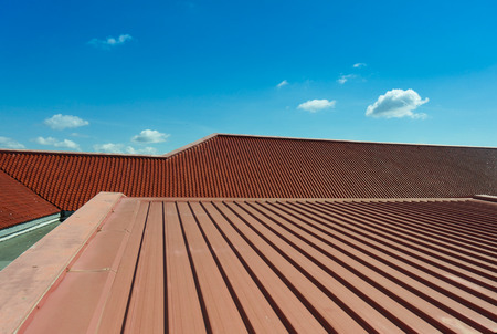 Architectural detail of metal roofing on commercial construction with blue sky background