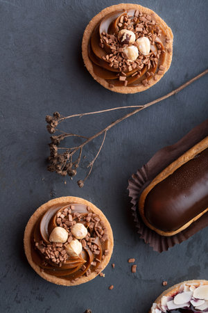 tartlet and filling eclair with milk cheese and lots of salted caramel with nuts on tartlets with cottage cheese or butter cream and caramel, delicious desserts. Tartlet backgroundの写真素材