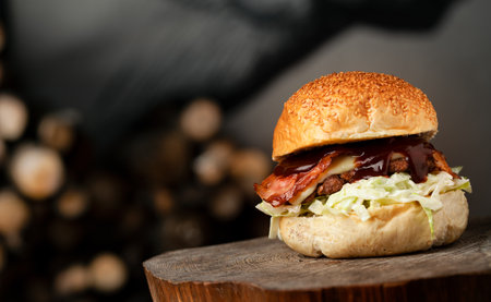 selective focus of tasty burger on beautiful gray background with painted wall, wood decorations. Typical restaurant burger for bars, grill bars, menu, fanpage. Homemade burgerの写真素材