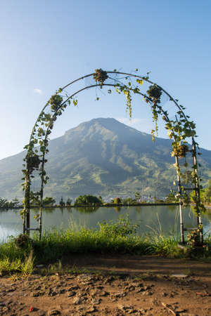 Garden arch with a view of the mountains and the lake.の写真素材