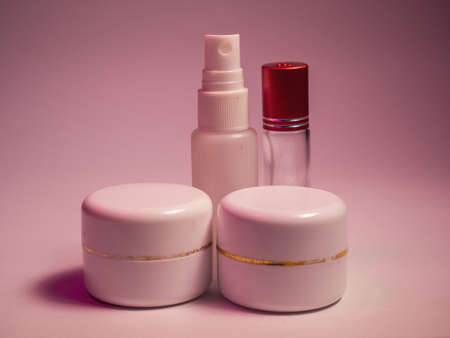 Cosmetic bottle containers with cream and lotion on pink background.の写真素材