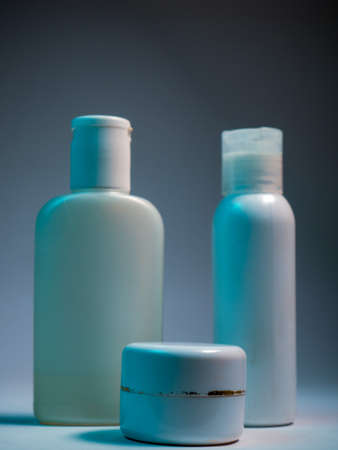 set of cosmetic bottles for cream, gel, lotion, shampoo, shower gel and conditioner on a blue backgroundの写真素材