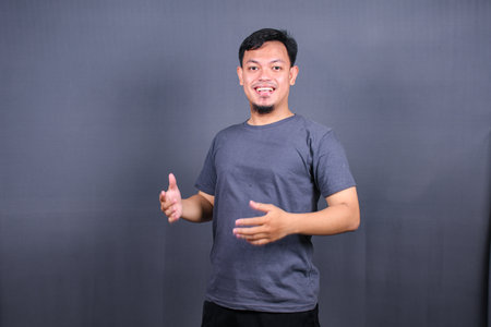 Young handsome asian man over gray background Smiling relaxed and cheerful Success and optimisticの写真素材