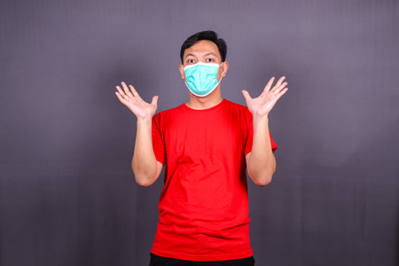 Effective protection against coronavirus. Asian Man wearing hygienic mask to prevent infection, respiratory illness such as flu, 2019-nCoV, Covid-19. isolated on gray backgroundの写真素材