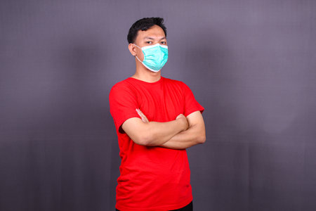 Effective protection against coronavirus. Asian Man wearing hygienic mask to prevent infection, respiratory illness such as flu, 2019-nCoV, Covid-19. isolated on gray backgroundの写真素材