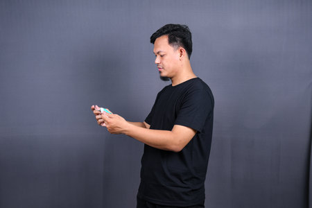 Asian man wearing a mouth protection or mask to prevent getting sick at work. Isolated on Gray Backgroundの写真素材