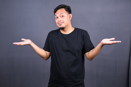 Closeup portrait asian young man shrugging shoulders. I don't know concept. Body language