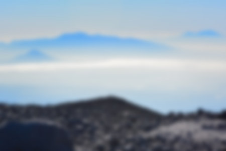 Blurred landscape blue sky with clouds, beautiful fantasy pastel colorful landscape background, gradient sky, sunrise with mountains in distantの写真素材