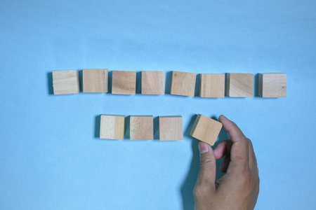 Hand arranging wood block stacking as step stair on blue background, Business growth concept